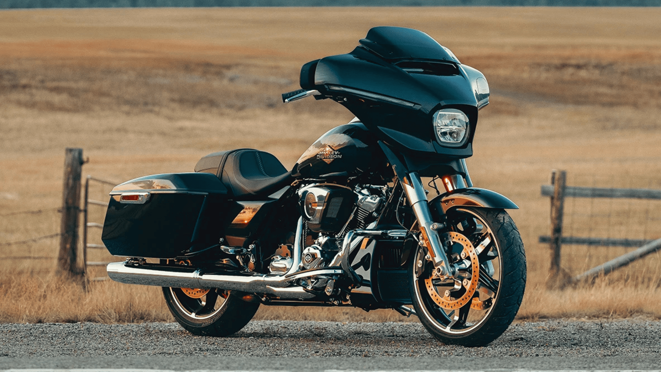 The 2025 Harley-Davidson® Street Glide® parked on a scenic rural road near Atlanta, GA. This sleek black touring motorcycle features a batwing fairing, chrome accents, and hard saddlebags, designed for long-distance comfort and performance. The open countryside background enhances the bike’s adventurous appeal.